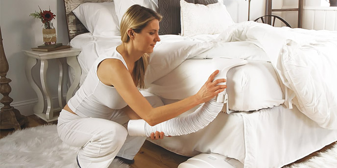 Woman Using a BedJet Bed Cooling System to Keep Her Bed Cool Without AC