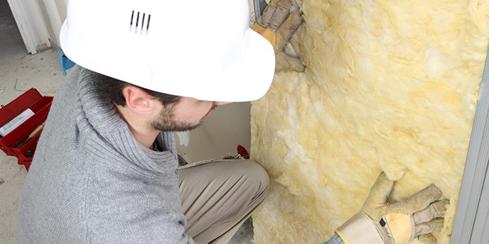 Man Installs Insulation in Wall